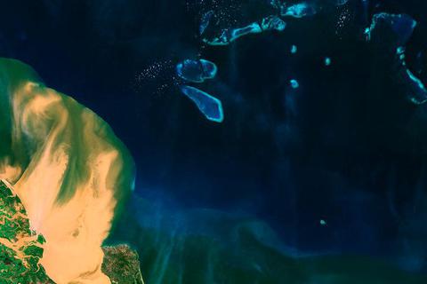 Sedimente strömen ins Meer vor der Küste Queenslands. Foto: ESA 
