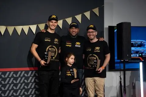 Niklas Koch mit Teamchef Ioannis Symrlis und Fahrerkollege Alex Koch (von links) bei der Siegerehrung der Porsche Endurance Trophy Nürburgring (PETN).