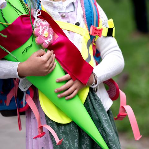 Schulkinder stehen an ihrem ersten Schultag mit ihren Schultüten an einer Grundschule.