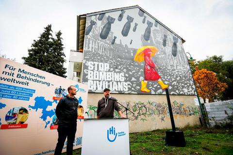 Die Graffiti-Wand "Stop bombing Civilians" stellen die Künstler Fabian Meuren (links) und Elmar Compes an der Heinheimer Straße 44. © Xenia Schipp