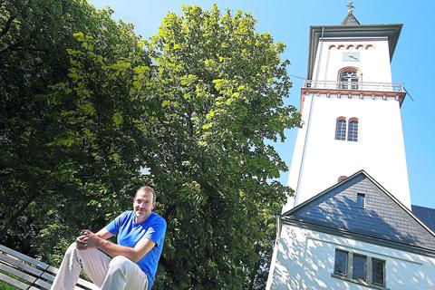 Pfarrer Jonas Bauer vor dem 500 Jahre alten Turm der Dreifaltigkeitskirche in Eberstadt. Andreas Kelm