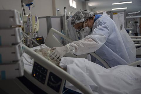Ein Intensivpfleger kümmmert sich um eine Patientin auf der Coronastattion. Foto: dpa