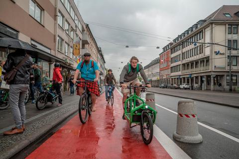 Kurz nach der Freigabe des neuen geschützten Radstreifens rollen die ersten Zweiräder entlang der Rheinstraße Richtung Innenstadt.   Foto: Marc Wickel 