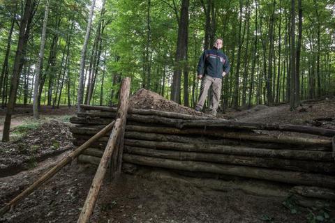 Matthias Kalinka, Bereichsleiter im Forstamt Darmstadt, verweist auf eine im Wald unweit der Burg Frankenstein illegal aufgetürmte Sprungschanze an der "Rinne", die meterweite Sprünge ermöglicht. Foto: dpa 