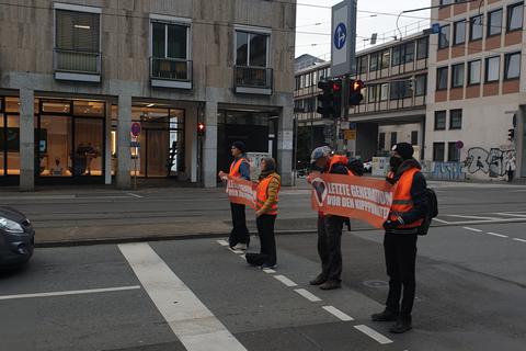 Drei Männer und eine Frau der Gruppe "Letzte Generation" blockieren am Dienstagvormittag die Kreuzung Rheinstraße/Grafenstraße. Zu größeren Behinderungen kommt es nicht.