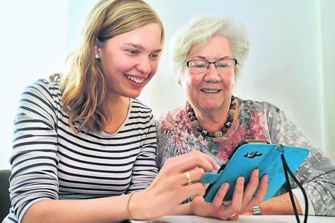 Maren Kniesz (links) hilft Hannelore Schildt, die viel zu vielen Fotos auf ihrem Smartphone zu sortieren - und großzügig zu löschen. Foto: Andreas Kelm 