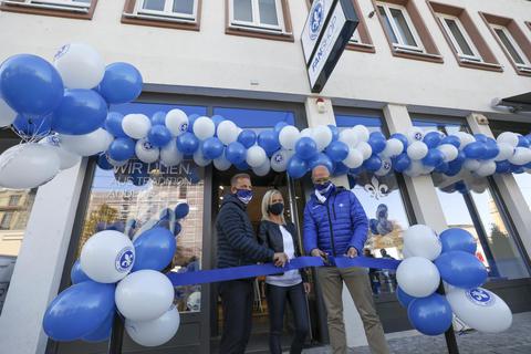 Mit dem symbolisch Banddurchschnitt eröffnen (von links) Trainer Markus Anfang, Filialleiterin Monika Seckert und Marketing-Geschäftsführer Martin Kowalewski den neuen Lilien-Fanshop. Foto: Guido Schiek