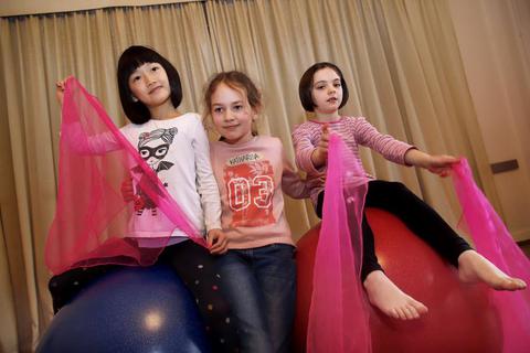 Anna (8), Katharina (9) und Claire (7, von links) proben im Nachbarschaftsheim für eine Jonglage-Nummer auf Bällen. Foto: Andreas Kelm   Foto: Andreas Kelm 
