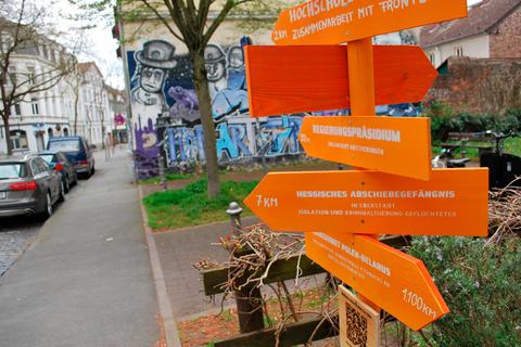 Die Seebrücke Darmstadt macht im Stadtbild mit ihren orangenen Wegweisern auf das Thema Flucht und Asyl aufmerksam. Seebrücke