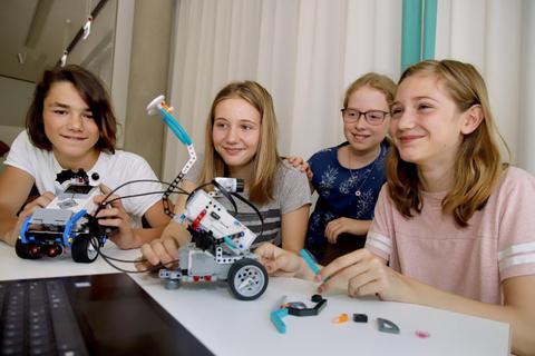 Beim Ferienprogramm im Fraunhofer-Institut SIT in der Rheinstraße 7  (von links) Fabian (14) mit Roboter Marta sowie Clara (13), Diana (11) und Charlotte (12) mit Roboter Otto. Foto: Andreas Kelm  Foto: Andreas Kelm