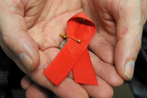 Eine rote Schleife ist das Symbol der Solidarität mit HIV-Positiven und Aids-Kranken. Archivfoto: dpa