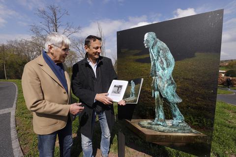 Ulrich Scheinert von der BS Kulturstiftung im Gespräch mit Künstler Carsten Costard vor einer Fotografie der Plastik „Der Dichter als flüchtiger Erdengast“ von Thomas Duttenhöfer. 