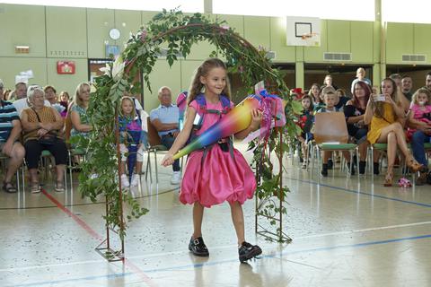 An der Astrid-Lindgren-Schule werden die neuen Erstklässler feierlich in Empfang genommen. Mia geht als erste durch den Rosenbogen.