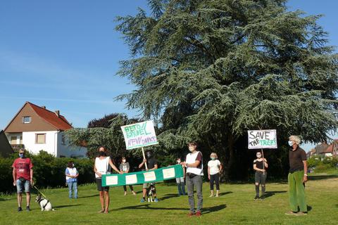 Mit Hunden und Abstand demonstrieren zehn Menschen für den Erhalt des Grünareals auf dem Turnvater-Jahn-Platz. Foto: Manfred Ofer
