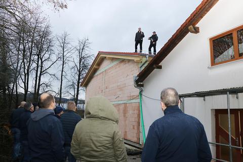 Der Rohbau der Kleiderkammer der Fürther Feuerwehr ist fertig. Frederik Fleck (links) trägt auf dem Dach des Neubaus den Richtspruch vor, Jochen Weber assistiert. Foto: Katja Gesche