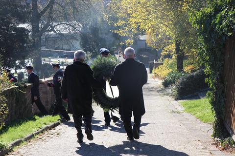 Bürgermeister Volker Oehlenschläger (rechts) und Ewald Pospischil, erster Beigeordneter der Gemeinde, tragen den Kranz zum Gedenkort auf dem Friedhof. © Katja Gesche