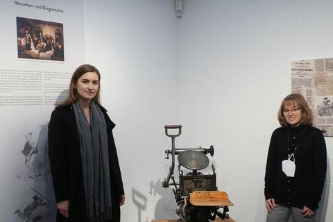 Zwei Jahre Vorarbeit: Museumsleiterin Luisa Wipplinger (links) und Stadtarchivarin Katrin Rehbein mit der Bostontiegel-Druckmaschine, die in der Sonderausstellung im Museum zu sehen ist. Foto: Jürgen Reinhardt