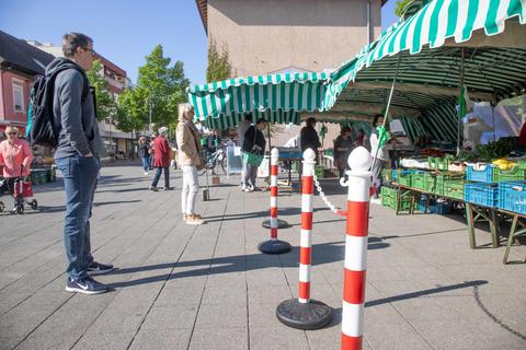 Mit Absperrungen werden die Kunden auf dem Schillerplatz auf Distanz gehalten. Foto: Thorsten Gutschalk