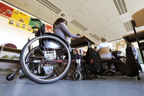 Eine behinderte Schülerin sitzt in ihrem Rollstuhl in einem Klassenraum. Archivfoto: dpa
