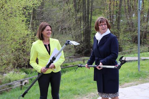 Die hessische Umweltministerin Priska Hinz (rechts) überreicht Angelika Beckenbach, Vorsitzende des Landschaftspflegevereins Bergstraße, zwei Astscheren. Foto: Katja Gesche