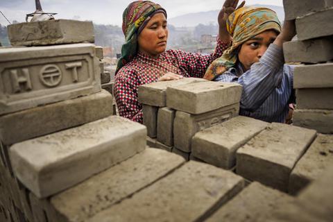 Arbeiterinnen tragen in Bagmati (Nepal) noch feuchte Ziegelsteine in Richtung des Brennofens einer Ziegelei. Zwei Bergsträßer Stiftungen arbeiten zusammen, um die Bildungschancen in dem Land zu erhöhen. Archivfoto: Jack Kurtz/dpa