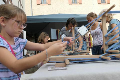 Vor dem Lindenfelser Museum durften sich die Besucher am Weben von Armbändern versuchen. Philipp Kriegbaum
