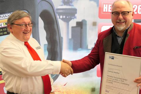 Martin Proba überreicht Geschäftsführer Rolf Ihrig (links) die Jubiläumsurkunde der IHK Darmstadt zum 25-jährigen Jubiläum der Firma. Foto: Philipp Kriegbaum