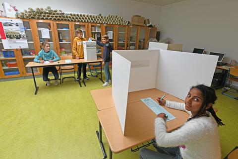 An der hessenweiten „Juniorwahl“ nimmt die Melibokusschule in Alsbach teil. Melina (von links) und Elija agieren als Wahlhelfer, Lasse und Hiba geben ihre Stimme ab. Foto: Dirk Zengel