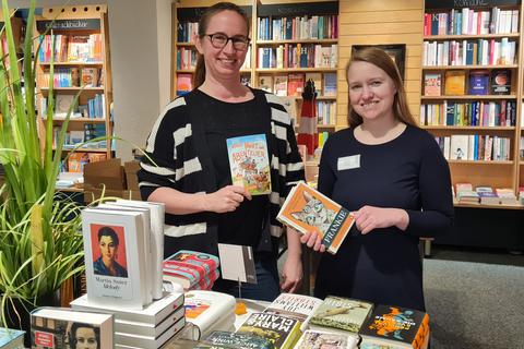 Buchhändlerin Katrin Gütte (links) mit "Volle Fahrt ins Abenteuer", das zum Welttag des Buches in Schulen gelesen wird. Lisa Gött zeigt ein Exemplar von "Frankie", das derzeit in der "Bücherinsel" stark nachgefragt wird.   