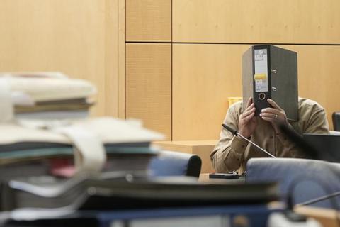 Der Angeklagte aus Breuberg verbirgt sein Gesicht im Gerichtssaal hinter einem Aktenordner. Foto: Marc Wickel 