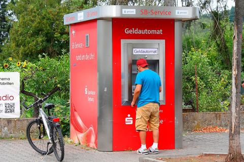 Önder Karach zieht gerade Geld am Automaten, aber er bezahlt nicht alles bar. Ulrike Bernauer
