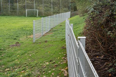 Ein Zaun soll den Bergspielplatz vor Wildschweinen schützen. Eltern bedauern, dass der Zaun nun den Spielplatz von einer Freifläche trennt. Foto: Marc Wickel