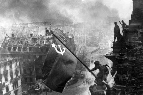 Ein sowjetischer Soldat hisst die Flagge auf dem Berliner Reichstag nach der Einnahme Berlins durch die Rote Armee am 30. April 1945. Es ist ein Symbolbild für das Ende des Zweiten Weltkriegs – und den Beginn des Kalten Krieges. Für damalige Kriegskinder spricht die Angst vor „dem Russen“ auch heute noch ein Feindbild an, das ihnen anerzogen worden ist. Der Krieg in der Ukraine öffnet für sie alte Wunden. Foto: dpa