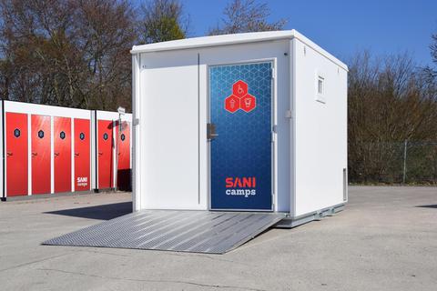 Eine Sani Camps Toilettenanlage für Menschen mit Behinderung, wie sie auch in Pfungstadt zum Einsatz kommen wird. Im Hintergrund sind weitere mobile Toilettenanlagen zu sehen, die sich mit kleinem Gerät transportieren lassen. Sani GmbH