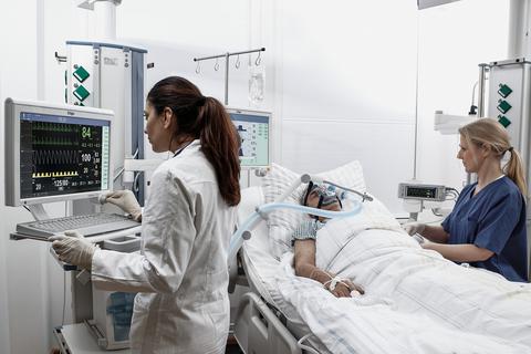 Medizinisches Personal überwacht die Vitalwerte eines auf Intensivstation beatmeten Patienten über Monitore des neuen Technologie-Partners der Kreiskliniken Dräger. 