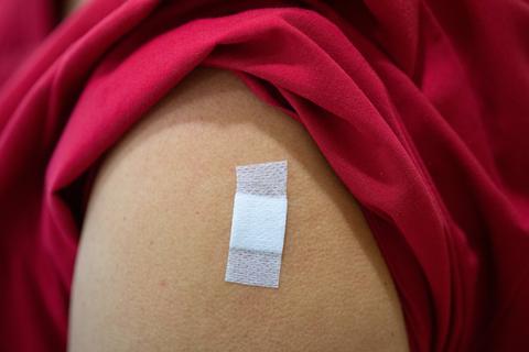 Eine Frau hat nach der Corona-Impfung ein Pflaster auf dem Oberarm kleben. Foto: dpa
