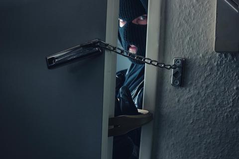 Ein Einbrecher verschafft sich Zutritt zu einer Wohnung.