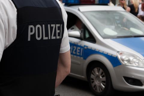 Ein Polizist steht vor einem Einsatzfahrzeug.