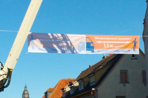 In luftiger Höhe sind in Münster Banner gespannt worden, um auf den vorgeschriebenen Mindestabstand zu Radfahrern aufmerksam zu machen. Foto: Rathaus