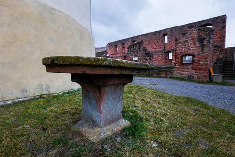 Der Altarstein, der im Hof der Veste Otzberg vor der "Weißen Rübe" steht, hat eine wechselvolle Geschichte. Die einstige Burgwirtin Christa Majer hatte 1968 auf einem Steinhaufen hinter dem Brunnenhaus die Tischplatte und den Fuß des Altarsteins entdeckt und ließ diesen aufstellen. Foto: Guido Schiek 