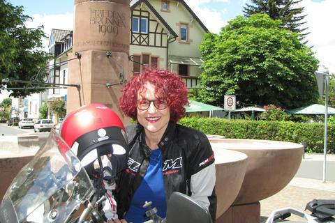 Viel Rot für eine Liberale: Kirsten Willenbücher mit Motorrad vor dem Friedensbrunnen in Jugenheim. Foto: Jürgen Buxmann