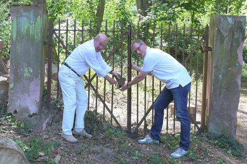 Das Tor muss von Erde, Geröll und Wurzeln befreit werden. Das Foto zeigt (Karl Listner vom Museumsverein, links) und Markus von Rüden (Miteigentümer). Foto: Dirk Zengel