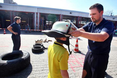 Vor der Fahrzeughalle der Weiterstädter Feuerwehr erklärt Rene Übel von der Einsatzabteilung  beim Tag der offenen Tür Ausrüstungsgegenstände. Foto: Karl-Heinz Bärtl