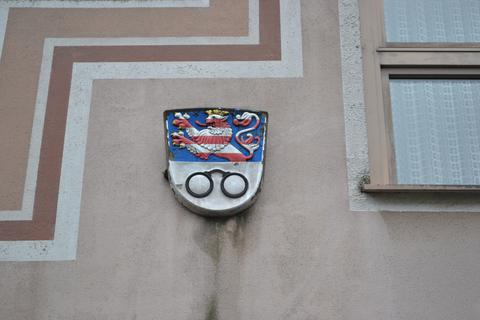 In Bischofsheim gibt es viel zu Entdecken. Erkennen Sie die Details? Hier ist das Bischofsheimer Wappen zu sehen, dass neben dem hessischen Löwen auch zwei Kreise zeigt, die durch einen Bogen verbunden sind. Ursprünglich sei das Gebilde scherzhaft als Brille bezeichnet worden, vermerkte Lehrer, Maler und Heimatforscher Georg Mangold (1863 bis 1945). 