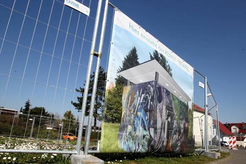 Bis jetzt gibt es den Bischofsheimer „Kunst-Würfel“ nur als Entwurfszeichnung – auf dem Zaun rund um den künftigen Bauplatz in der Hans-Dorr-Allee. Foto: hbz /Jörg Henkel