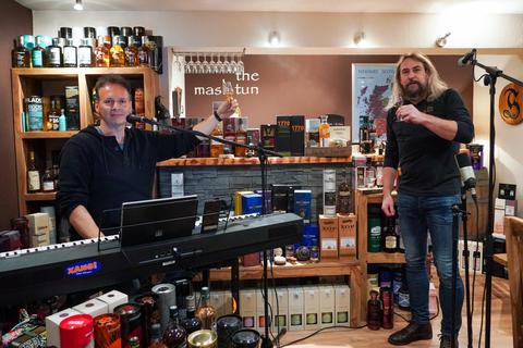 Beim Online-Whisky-Tasting im Büttelborner Mash Tun sorgt Moderator Ralf Baitinger auch für die Musik, während Inhaber Robby Hoffmann Erläuterungen gibt. Foto: Vollformat/Marc Schüler