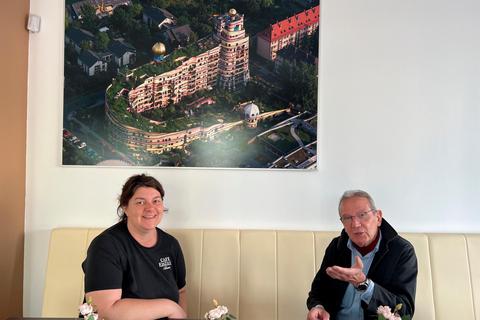 Hans J. Jansen und Arzu Pantani vom Café Eiszeit vor der Luftbildaufnahme des Hundertwasserhauses. Daniela Hamann