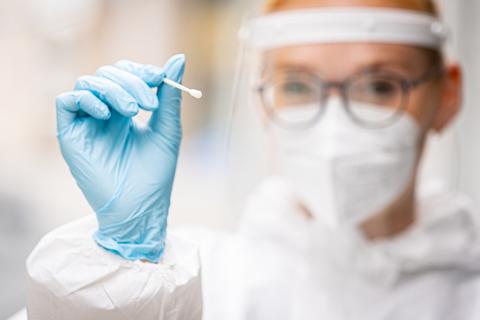 Eine Mitarbeiterin eines Testzentrums hält einen Teststab für einen Schnelltest auf das Coronavirus in ihren Händen.  Foto: Moritz Frankenberg/dpa