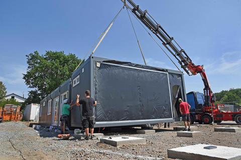 Das Containerelement schwebt an seinen künftigen Platz: Vier solcher Einheiten werden derzeit zu einer Wohnung zusammengefügt. Acht Wohnungen für Obdachlose oder geflüchtete Menschen sollen demnächst bezugsfertig sein. Foto: Vollformat/Ursula Friedrich