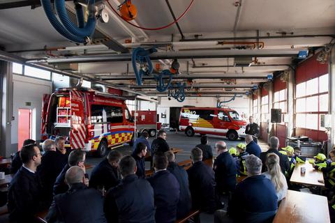 Feierstunde im Spritzenhaus: Wehrführer Marco Schmitz (rechts, hinten) begrüßt die Feuerwehrleute und Besucher, die gleich drei Neuzugänge in der Mörfelder Fahrzeugflotte feiern. Foto: Friedrich